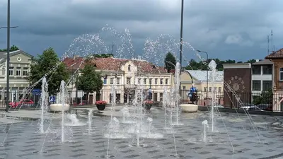 a fountain in the middle of a city with buildings at Vilkmerge apartment in Ukmergė