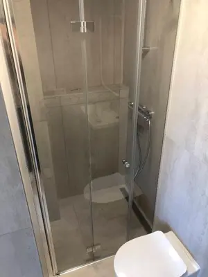 a shower stall with a toilet in a bathroom at TWIX dvi skirtingos gretimos erdvės in Birštonas