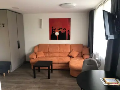 a living room with a couch and a table at TWIX dvi skirtingos gretimos erdvės in Birštonas