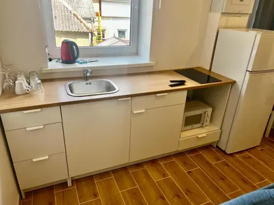 a kitchen with a sink and a refrigerator at Gedimino 19 apartments in the old town of Ukmergė in Ukmergė