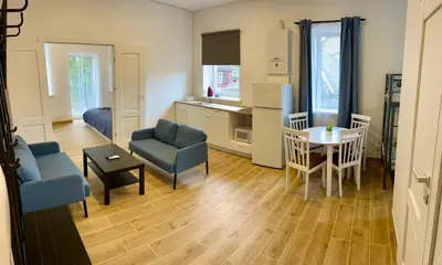 a living room with a table and chairs and a kitchen at Gedimino 19 apartments in the old town of Ukmergė in Ukmergė