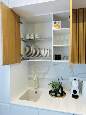 a kitchen with a sink and a cupboard with dishes at Žaliakalnis Suites in Kaunas