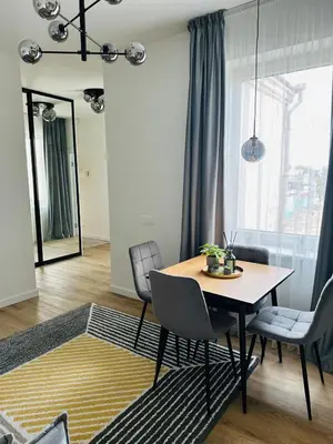 a dining table and chairs in a living room at Žaliakalnis Suites in Kaunas