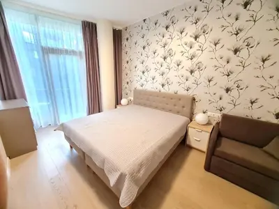 a bedroom with a bed and a chair at Saulės Muzika in Druskininkai