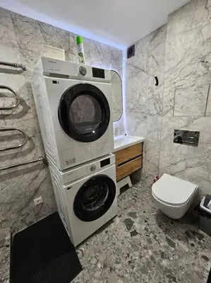 a bathroom with a washing machine and a toilet at Trakai City apartment 2-bedroom in Šiauliai
