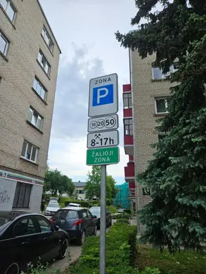 a parking sign on a pole in front of a building at Trakai City apartment 2-bedroom in Šiauliai