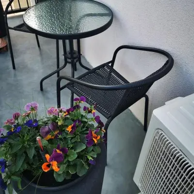 a table and a chair with a pot of flowers at Feels like home - Jauku kaip namuose in Kaunas