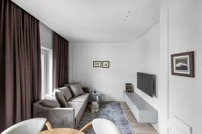 a living room with a couch and a tv at Feels like home - Jauku kaip namuose in Kaunas