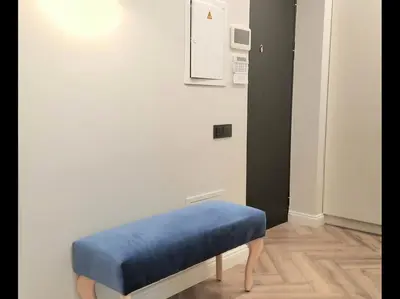 a blue ottoman sitting in a corner of a room at HaPPy iNN Brilliant Old Town self check in, Underground Parking, Terrace in Vilnius