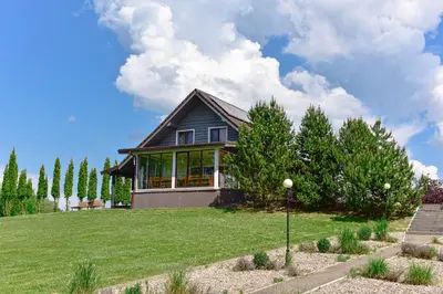 a house on a hill with a green yard at Green Harmony in Antalgė