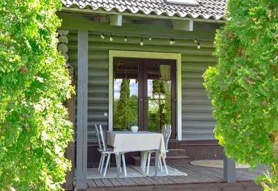 a table and chairs on the porch of a house at Green Harmony in Antalgė