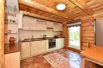 a kitchen with white cabinets and a wooden ceiling at Green Harmony in Antalgė