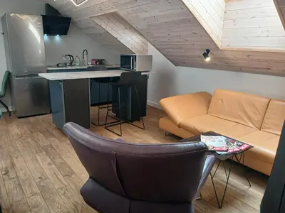 a kitchen and living room with a couch and a table at Loft style studio in the Old Town in Kaunas