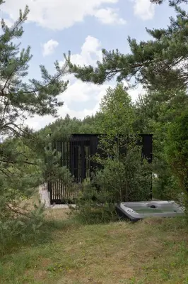 a bath tub sitting in the grass next to a fence at Konga Stay M - Private Jacuzzi Included in Strakiškiai