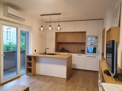 a kitchen with white cabinets and a island with a sink at Apartment with Terrace in Vilnius