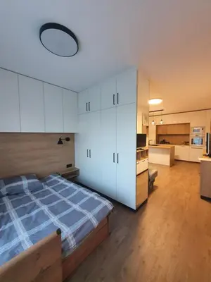 a bedroom with a large bed and a kitchen at Apartment with Terrace in Vilnius