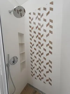 a bathroom with a shower and a wall with brown squares at Apartment with Terrace in Vilnius