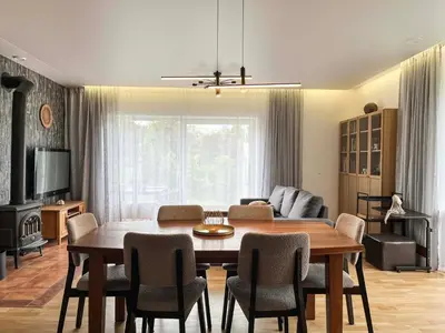 a living room with a table and chairs and a couch at Calm garden Suite near Green Lakes in Vilnius