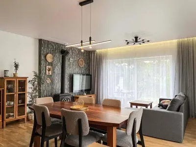 a living room with a wooden table and chairs at Calm garden Suite near Green Lakes in Vilnius