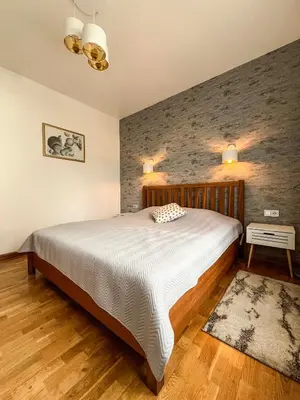 a bedroom with a large bed and a brick wall at Calm garden Suite near Green Lakes in Vilnius
