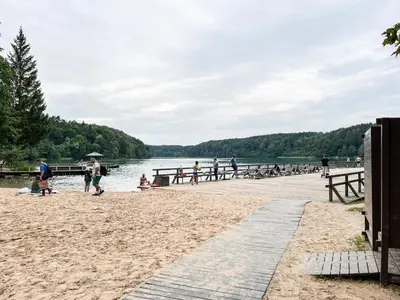 a group of people on a beach near the water at Calm garden Suite near Green Lakes in Vilnius