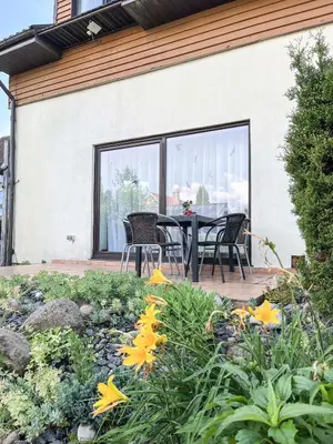a patio with a table and chairs and flowers at Calm garden Suite near Green Lakes in Vilnius