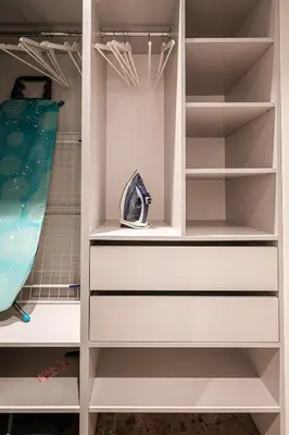 a walk in closet with white shelves at Scandinavian style apartment in Vilnius
