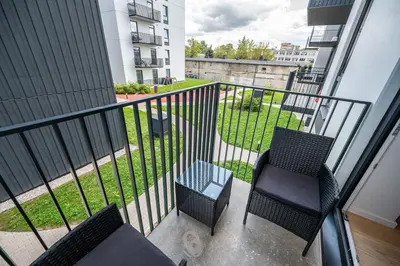 a balcony with two chairs and a view of a yard at Scandinavian style apartment in Vilnius