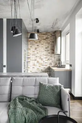 a living room with a white couch and a kitchen at Boutique Studio with Free Parking & AC in Kaunas