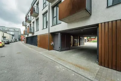 a building with a parking garage on a city street at Boutique Studio with Free Parking & AC in Kaunas