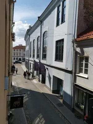 a city street with buildings and people walking down a street at Saviciaus in Vilnius