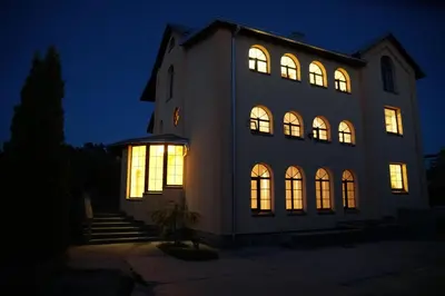 a large building with illuminated windows at night at A Tranquil Oasis, Lakeview Home in Lapes Kaunas in Lapės