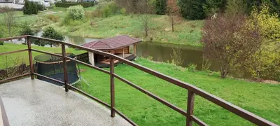 a view of a river with a house on a bridge at A Tranquil Oasis, Lakeview Home in Lapes Kaunas in Lapės