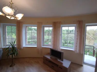 a living room with windows and a flat screen tv at A Tranquil Oasis, Lakeview Home in Lapes Kaunas in Lapės