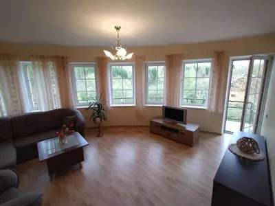 a living room with a couch and a tv at A Tranquil Oasis, Lakeview Home in Lapes Kaunas in Lapės