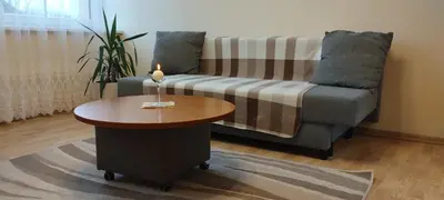 a living room with a couch and a candle on a table at A Tranquil Oasis, Lakeview Home in Lapes Kaunas in Lapės