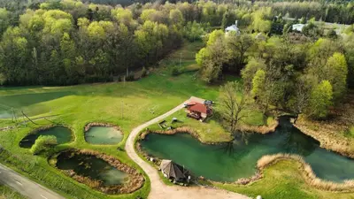 an aerial view of a house on a hill next to a lake at Bačkis camp in Bačkonys