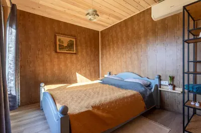 a bedroom with a blue bed in a wooden wall at Bačkis camp in Bačkonys
