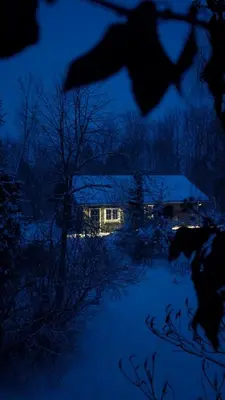 a house at night with snow on the ground at Svečių namelis KNYGŲ NAMAS in Kelmė