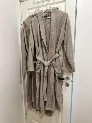 a robe hanging on a door in a room at Svečių namelis KNYGŲ NAMAS in Kelmė