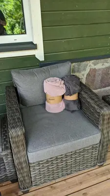 a wicker chair with two hats on top of it at Svečių namelis KNYGŲ NAMAS in Kelmė