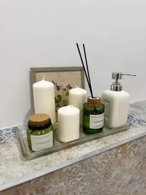 a tray with candles on a counter in a bathroom at Svečių namelis KNYGŲ NAMAS in Kelmė