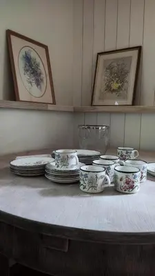 a table with plates and cups and dishes on it at Svečių namelis KNYGŲ NAMAS in Kelmė
