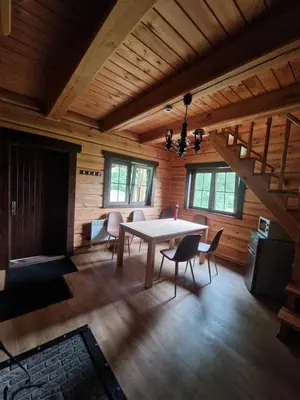a dining room with a table and chairs in a cabin at Pirtis su ežero pakrante Trakai in Salkininkai