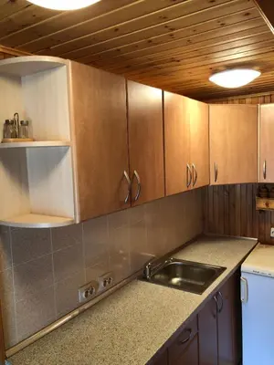 a kitchen with wooden cabinets and a sink at Poilsiadienis in Aukštadvaris