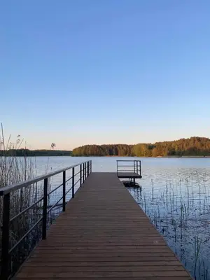 a wooden pier with a bench on the water at Poilsiadienis in Aukštadvaris