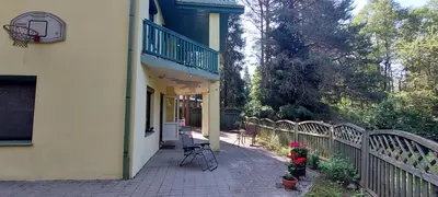 a porch of a house with a fence at Žalioji vila in Varteliai