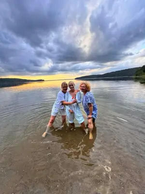 three children playing in the water on a lake at Žalioji vila in Varteliai