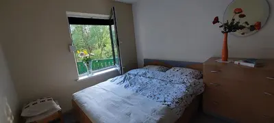 a bedroom with a bed and a dresser and a window at Žalioji vila in Varteliai