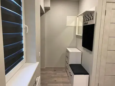 a small kitchen with white cabinets and a black bench at A&D Apartament in Kaunas